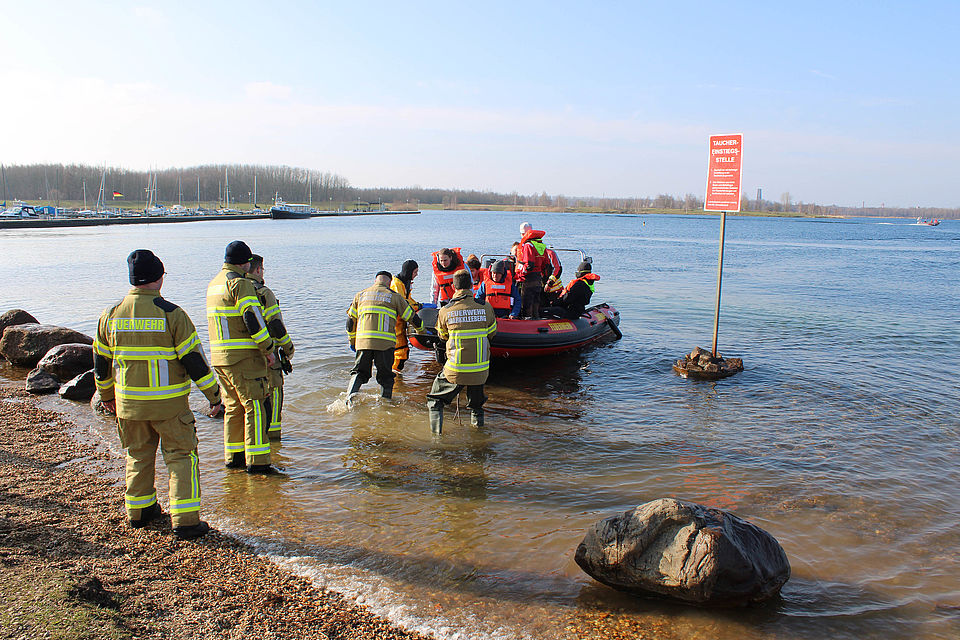 Feuerwehrleute ziehen Boot an Land