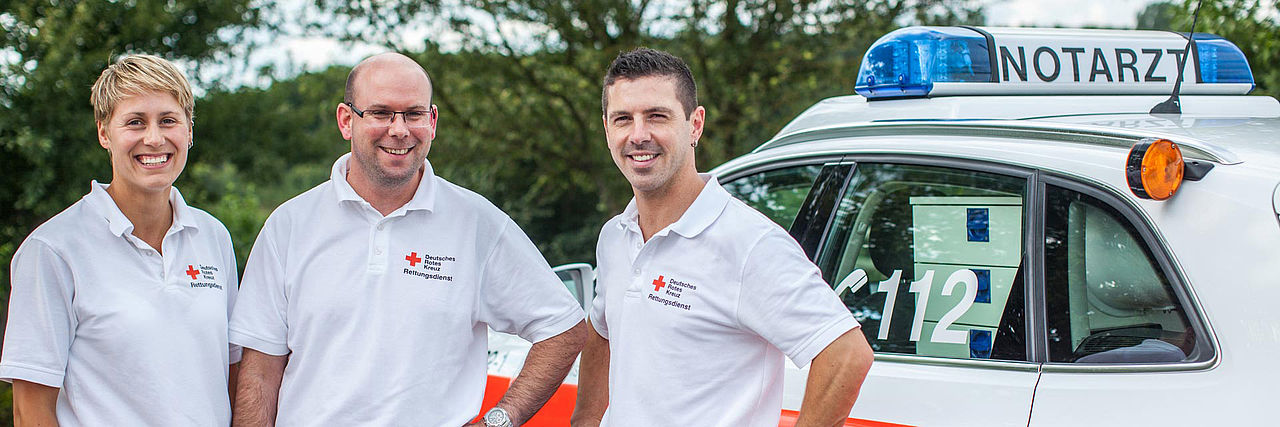 Ein Einsatzteam des Rettungsdienst vor einem Notarzteinsatzfahrzeug