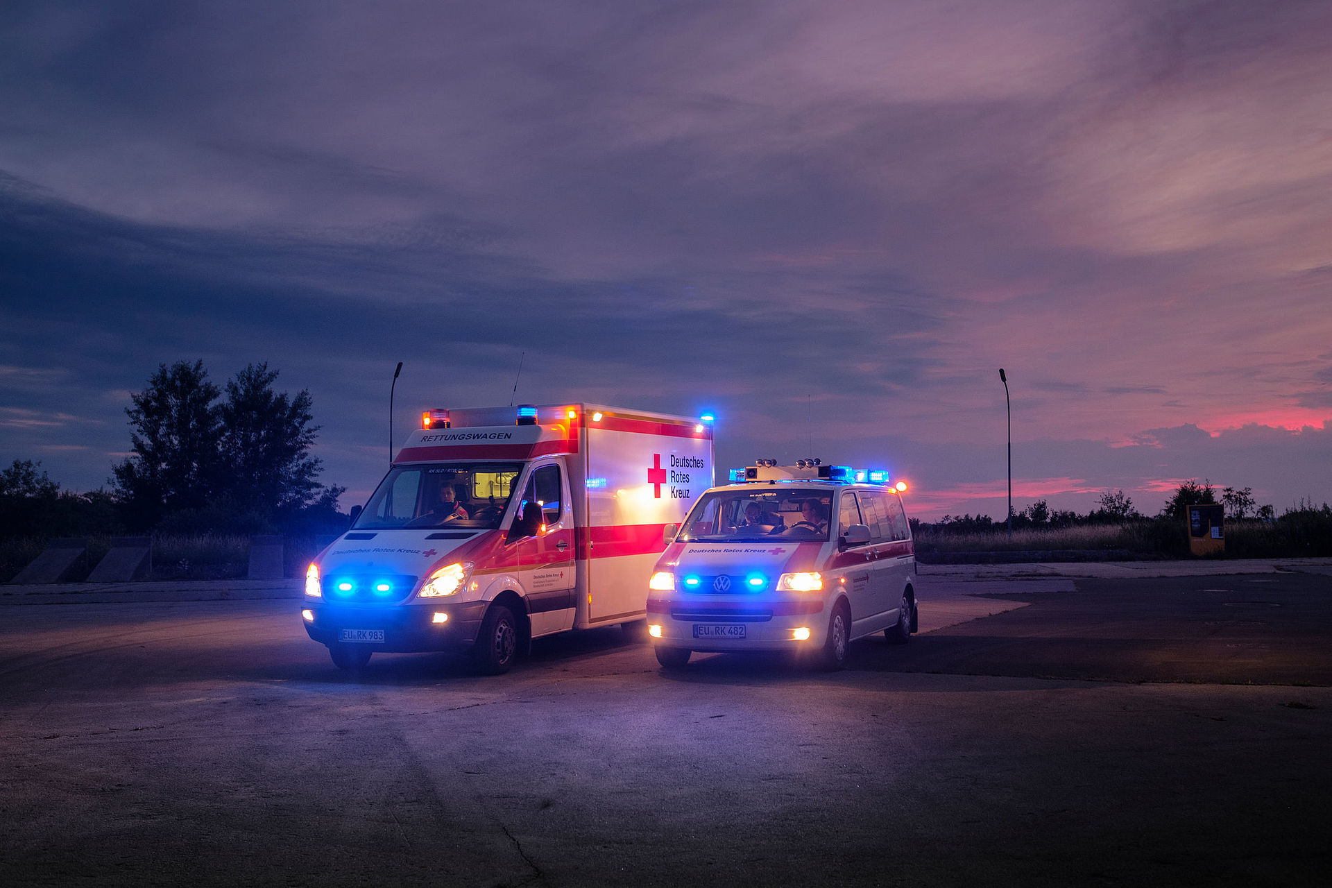 RTW und NEF stehen mit Blaulicht im Sonnenuntergang